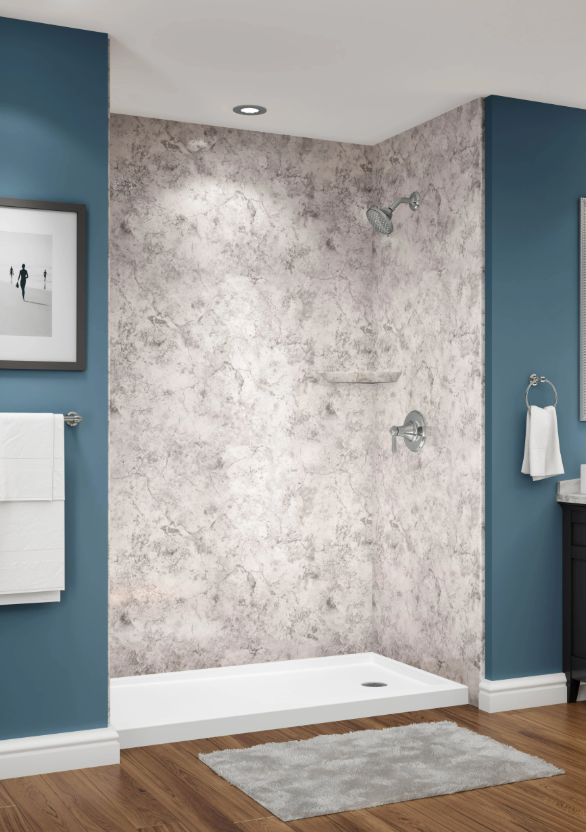 Bathroom shower with a textured gray accent wall, chrome showerhead, and control, surrounded by blue walls, wooden floor, and a gray rug.