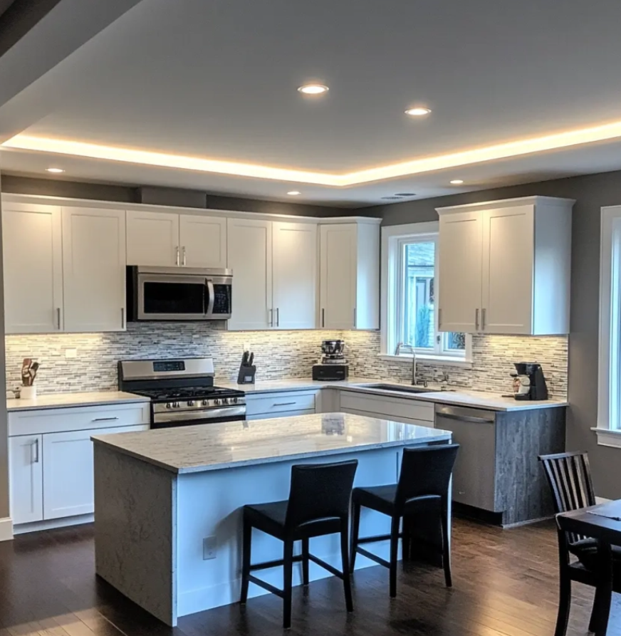 Modern kitchen with white cabinets, granite countertops, a kitchen island, stainless steel appliances, and dark wood flooring.