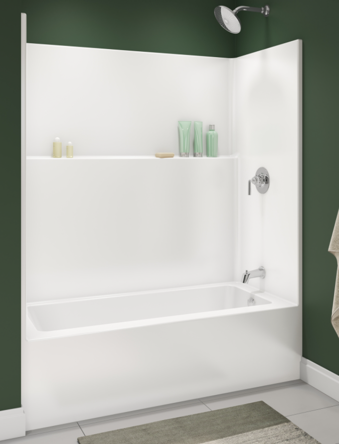 Bathroom with a white bathtub encased in a white surround, green walls, and a showerhead. Bottles of toiletries are placed on a ledge above the bathtub, and a towel hangs on the right side.