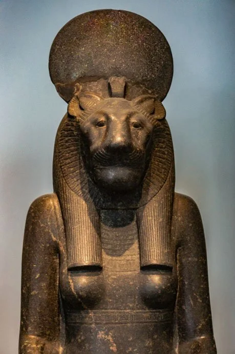 Stone statue of the Goddess Sekhmet showing Her upper torso and lioness head crowned with the iaret cobra and aten disk.