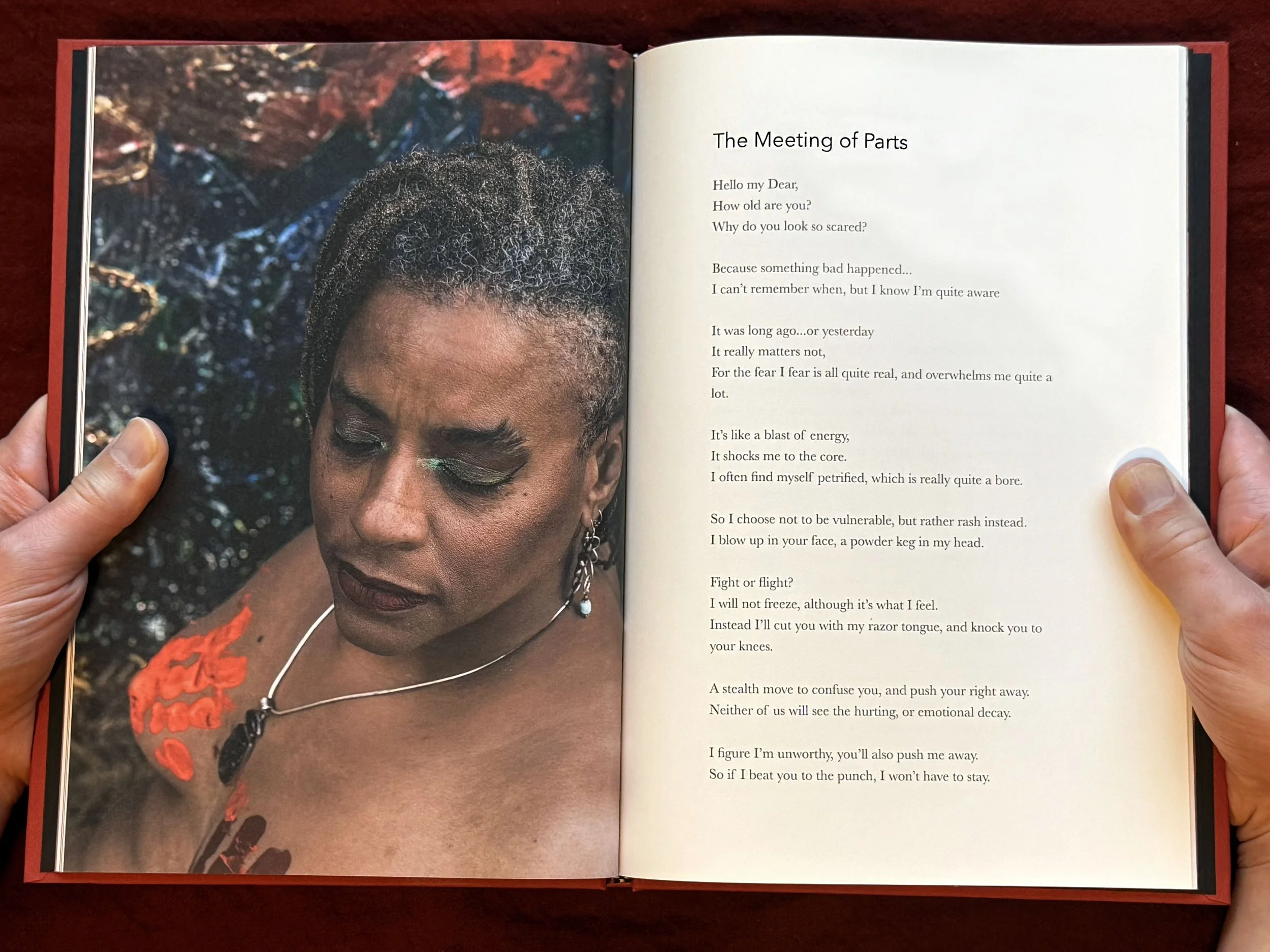 Open book with left page color image of woman before abstract painting, right page sparce text with title "The Meeting of Parts".
