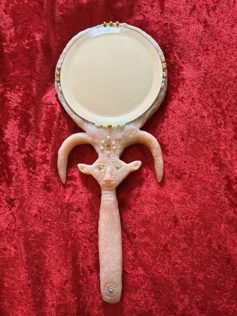 Mirror with a glass reflective face and a clay handle shaped like the face of Hathor.