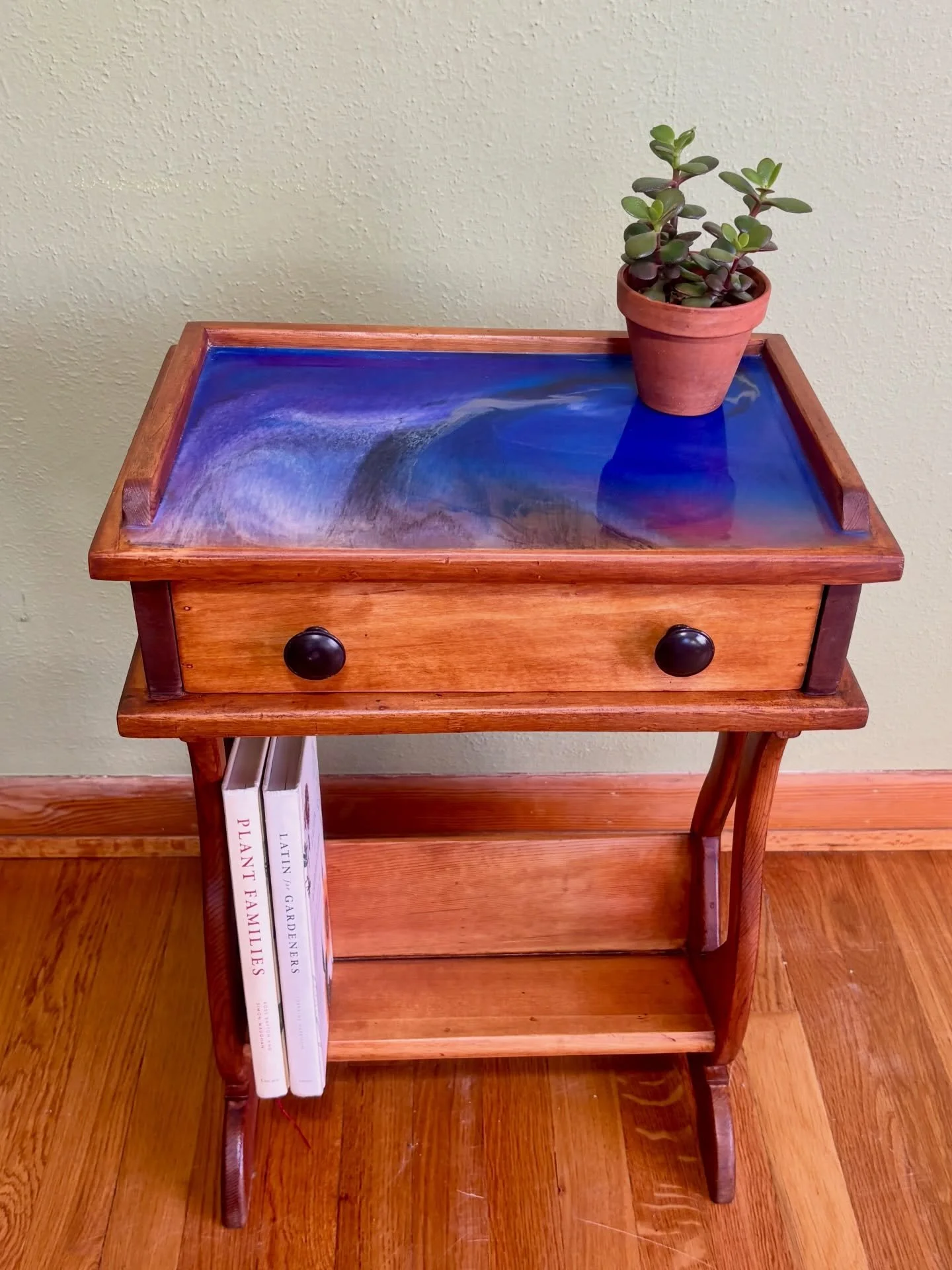 *FOR SALE*  wood side table with one-of-kind epoxy resin top (wait, one-of-kind?! omg gasp!) the top is a custom pour, no two resin pours are the same 💙

the deets
🛸 solid wood refinish with warm cherry finish
🛸 custom epoxy top
🛸 storage drawer 