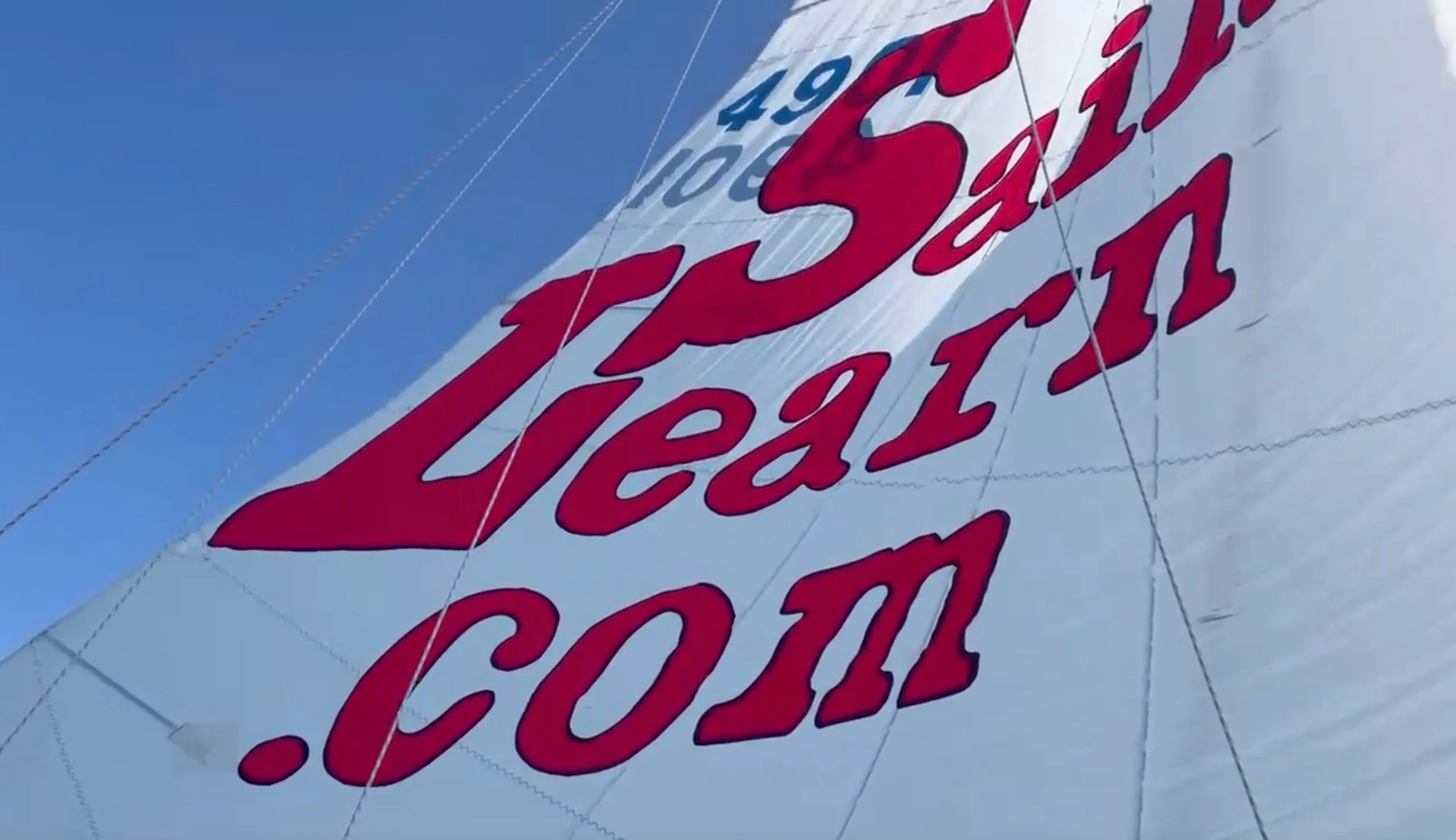 Mainsail advertisement via adhesive-backed red insignia cloth.