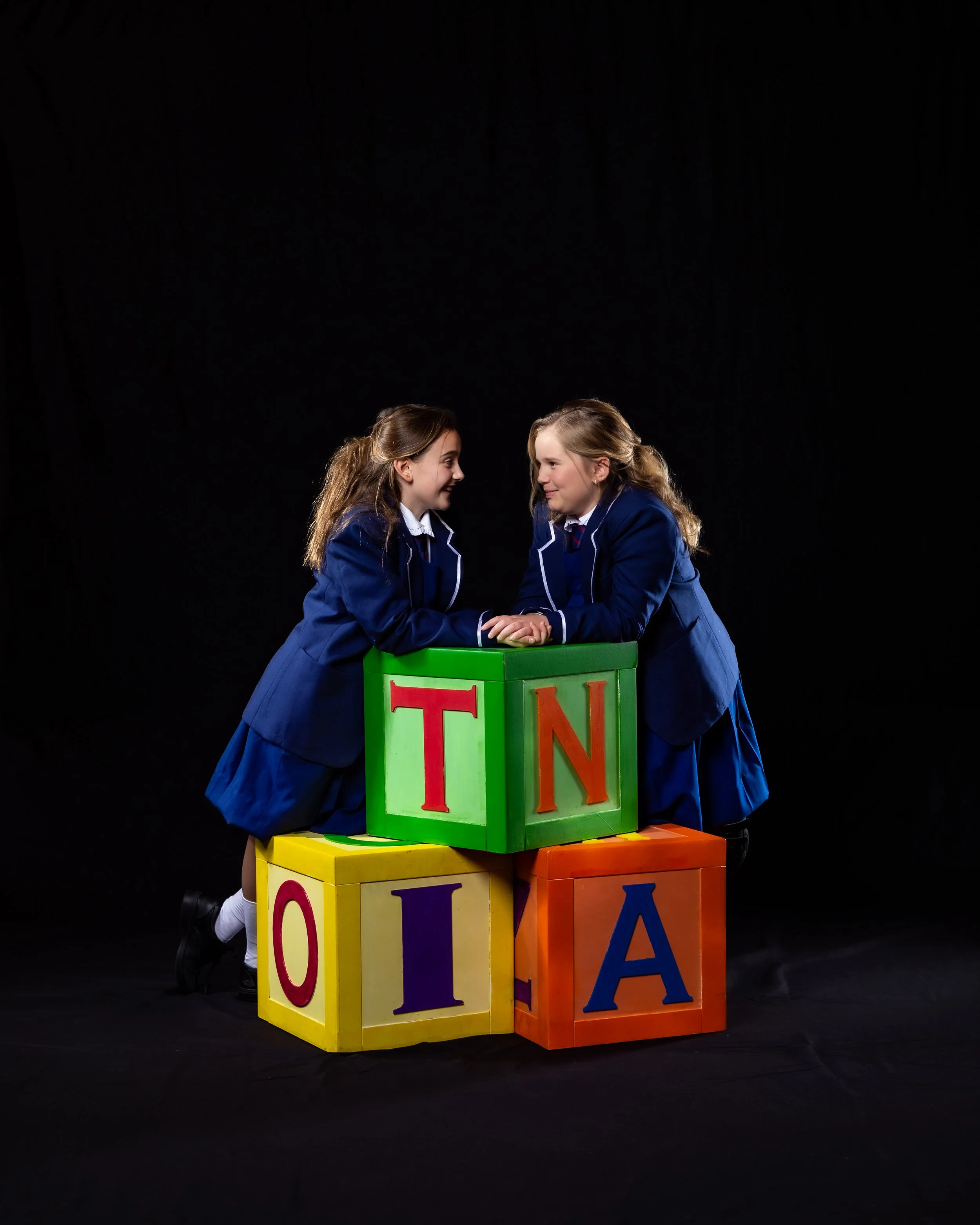 two girls playing matilda smiling