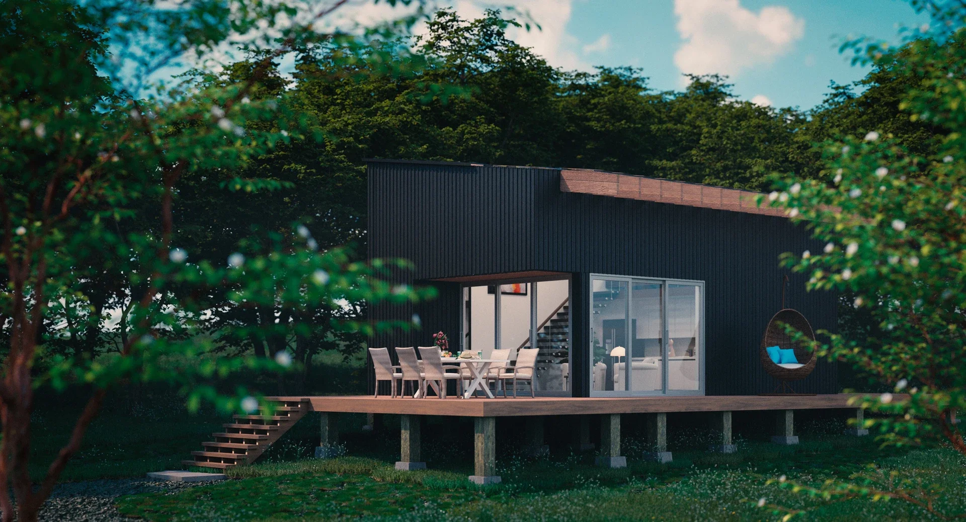 Modern house with a wooden deck surrounded by trees, outdoor dining table with chairs, and a hanging hammock chair with blue cushions.