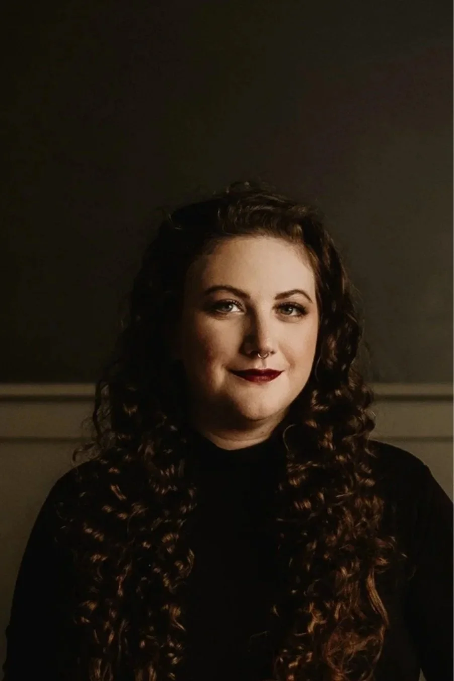 A woman with dark curly hair and fair skin