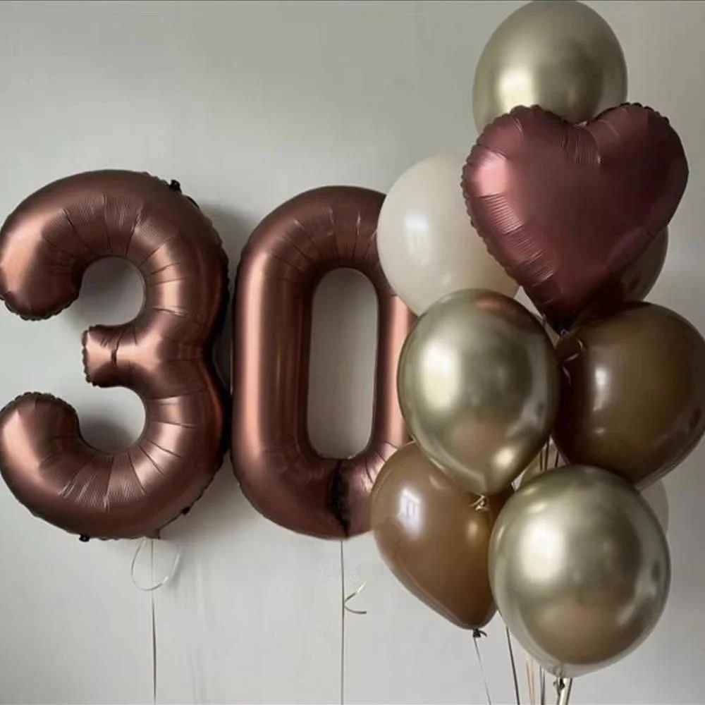 Balloon decorations for a 30th celebration, featuring two large rose gold number balloons, various metallic balloons, and a metallic heart-shaped balloon.
