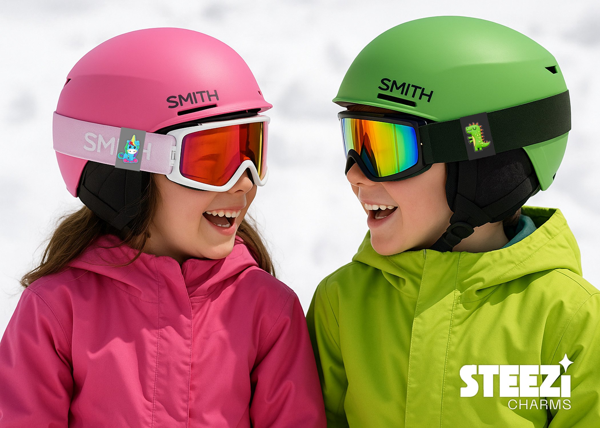 Two children wearing colorful ski helmets and goggles, smiling at each other in a snowy setting.
