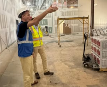 Dr. Trevor Ivey wearing a hard hat while touring the construction progress of a new school facility.