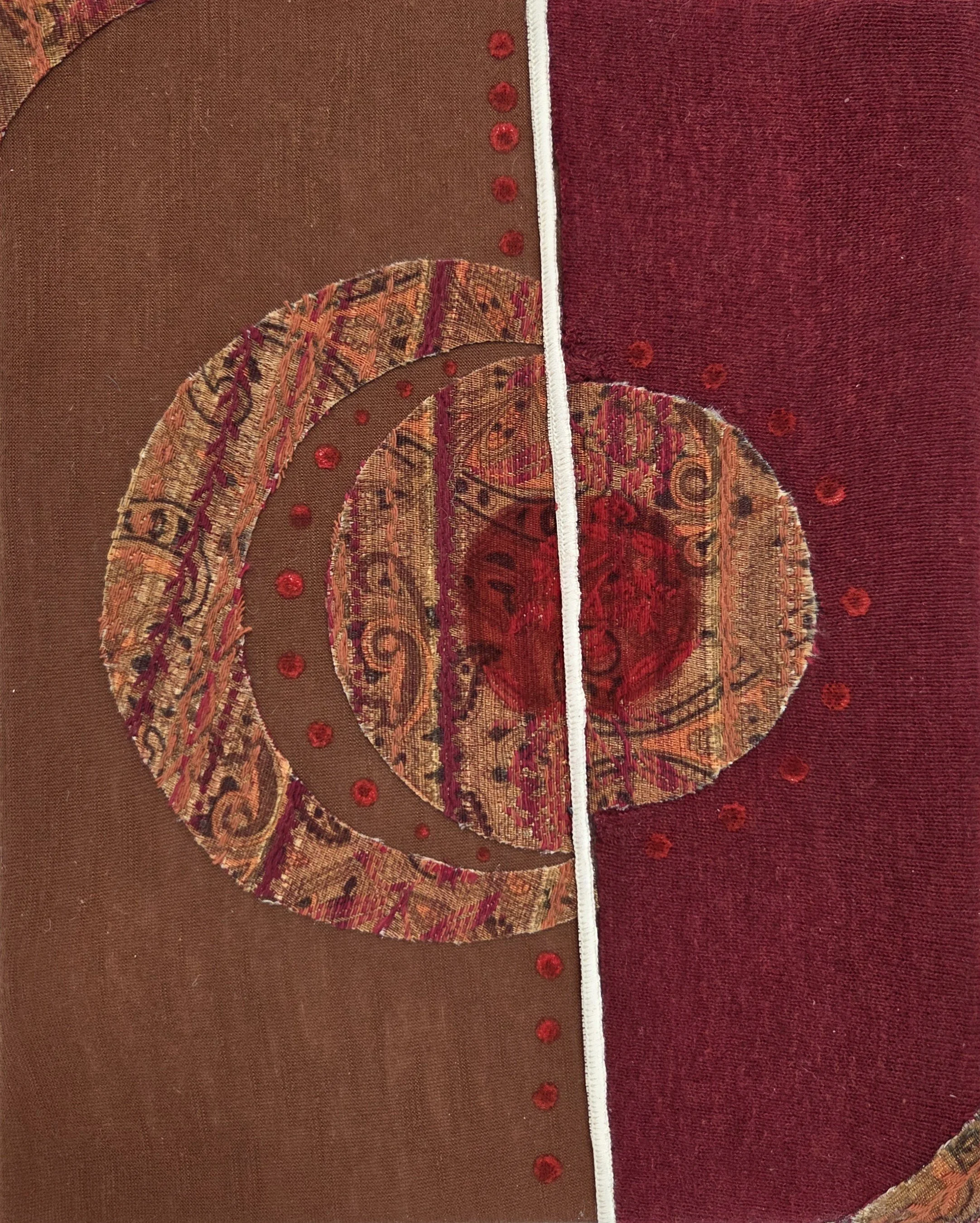 Fabric collage with intricate patterns and designs. Left section is brown with a circular design and red dots, while the right section is maroon with small red dots.