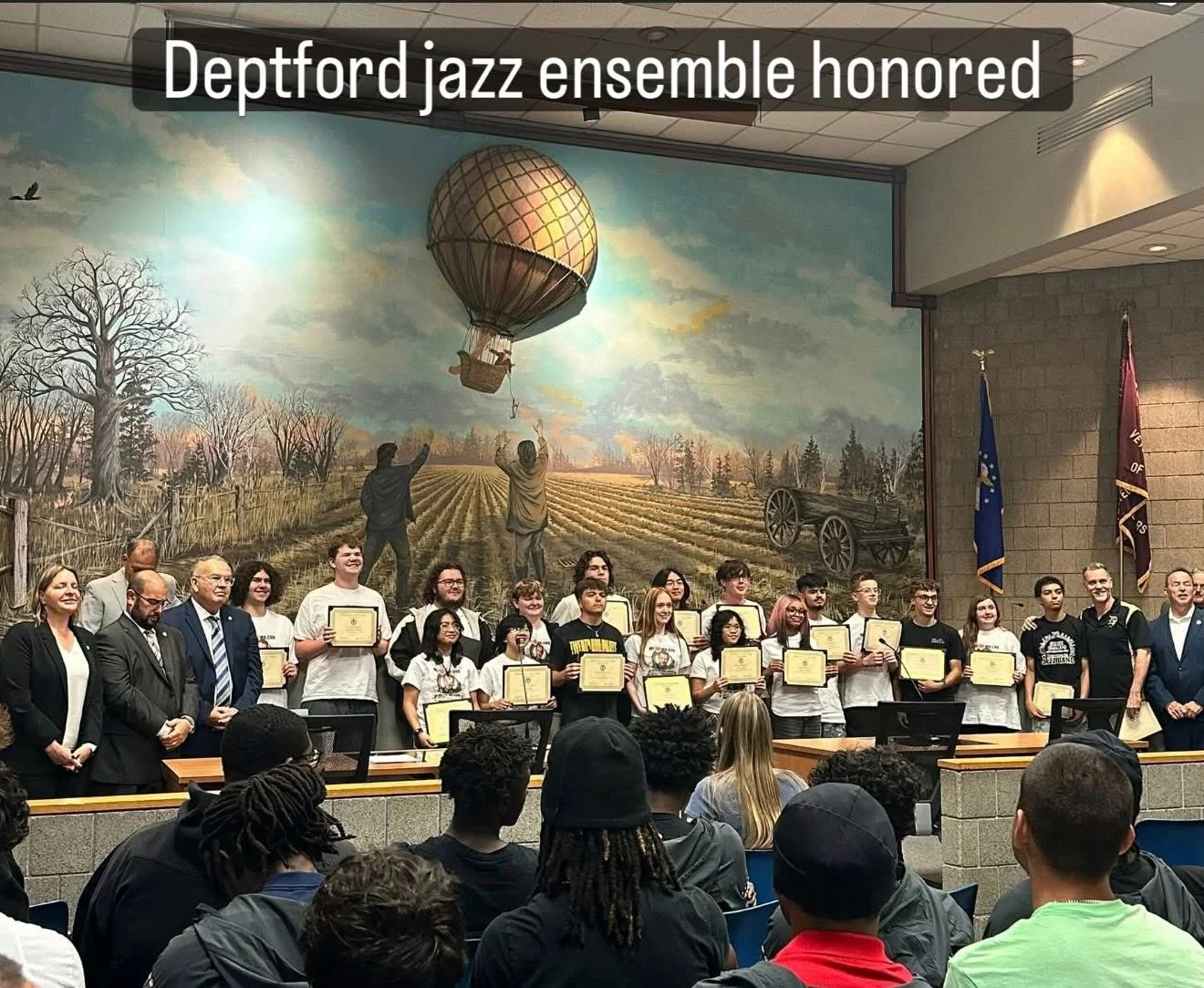 Group photo of students and officials at an award ceremony.  The students are holding certificates and posing for the photo. Carl Cox's Students in the Jazz Ensemble are being recognized for their wins at national and state competitions.