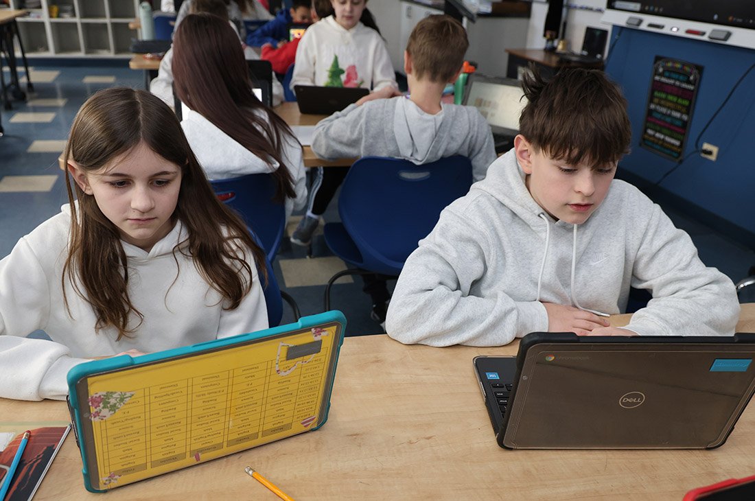 Students working on laptops in a classroom.