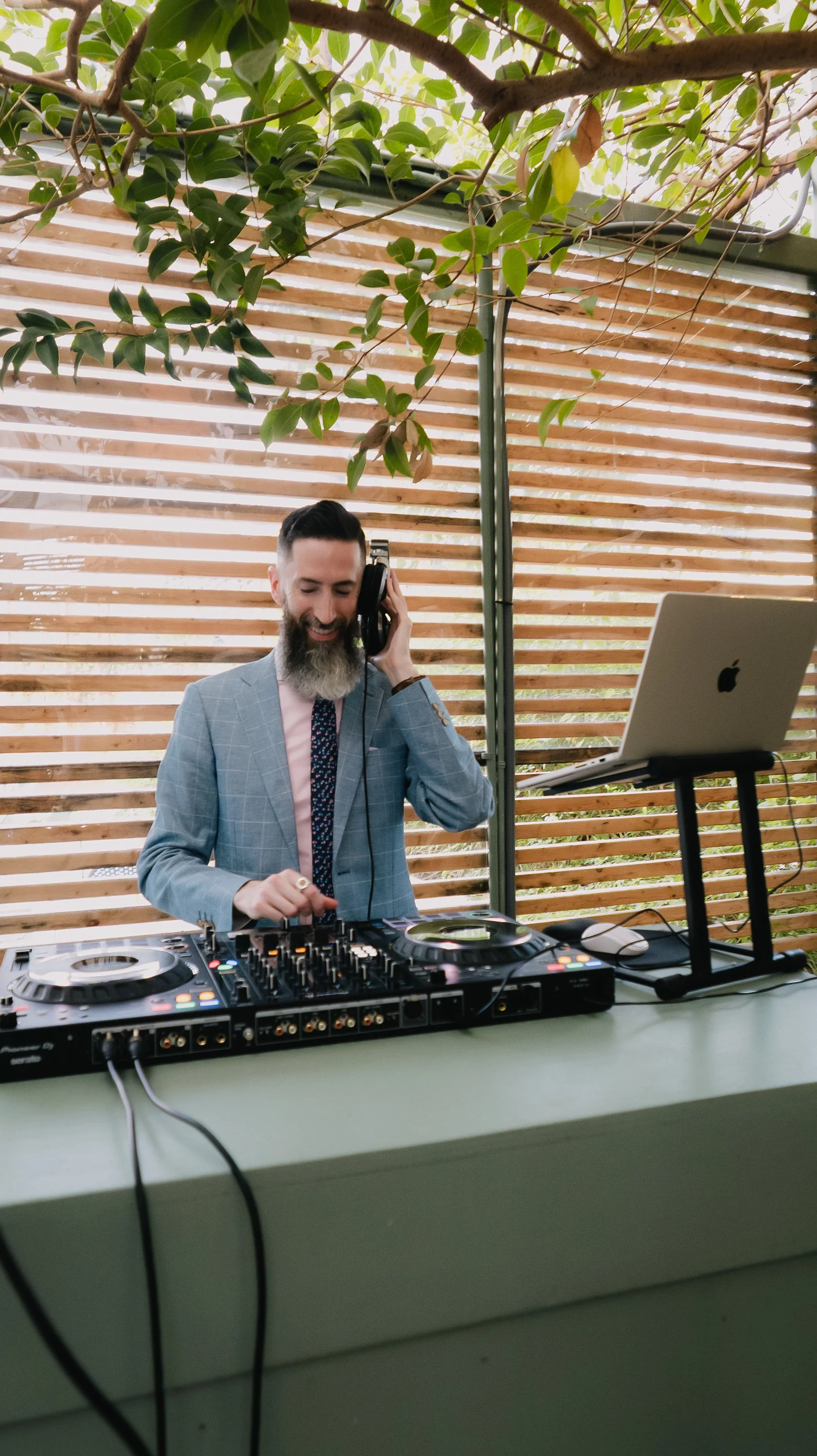 A DJ standing in front of his mixer and laptop