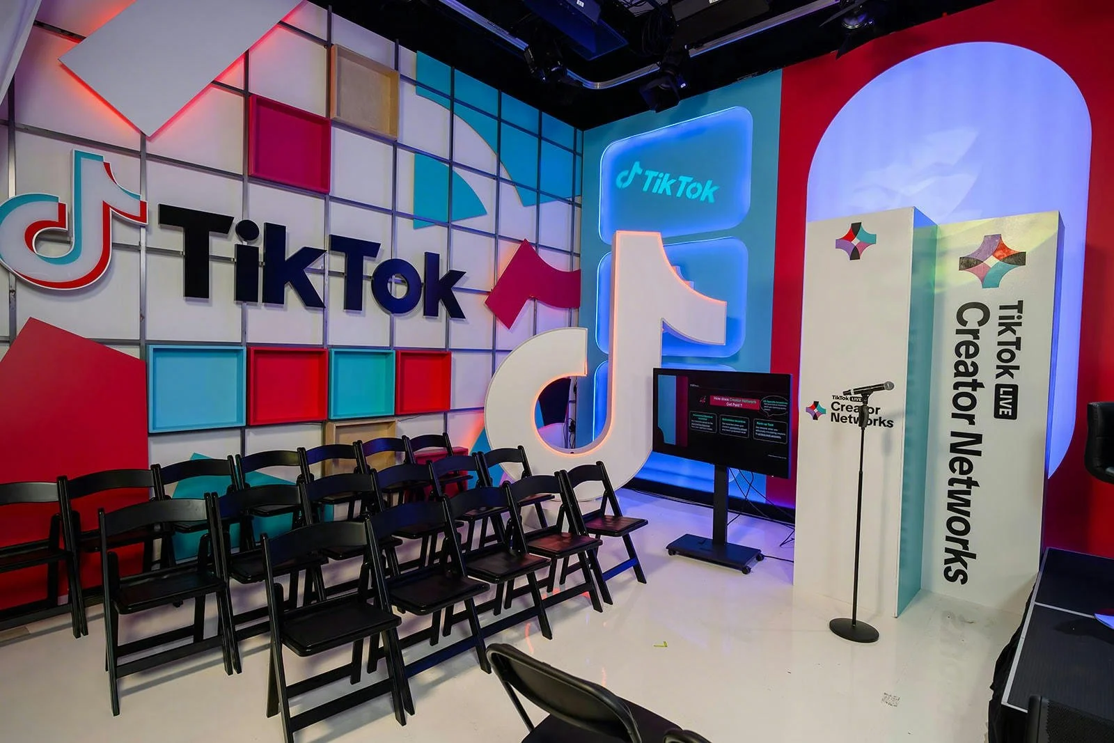 A conference room at TikTok's headquarters, featuring a stage, microphone and branded TikTok banners and signage throughout the room.