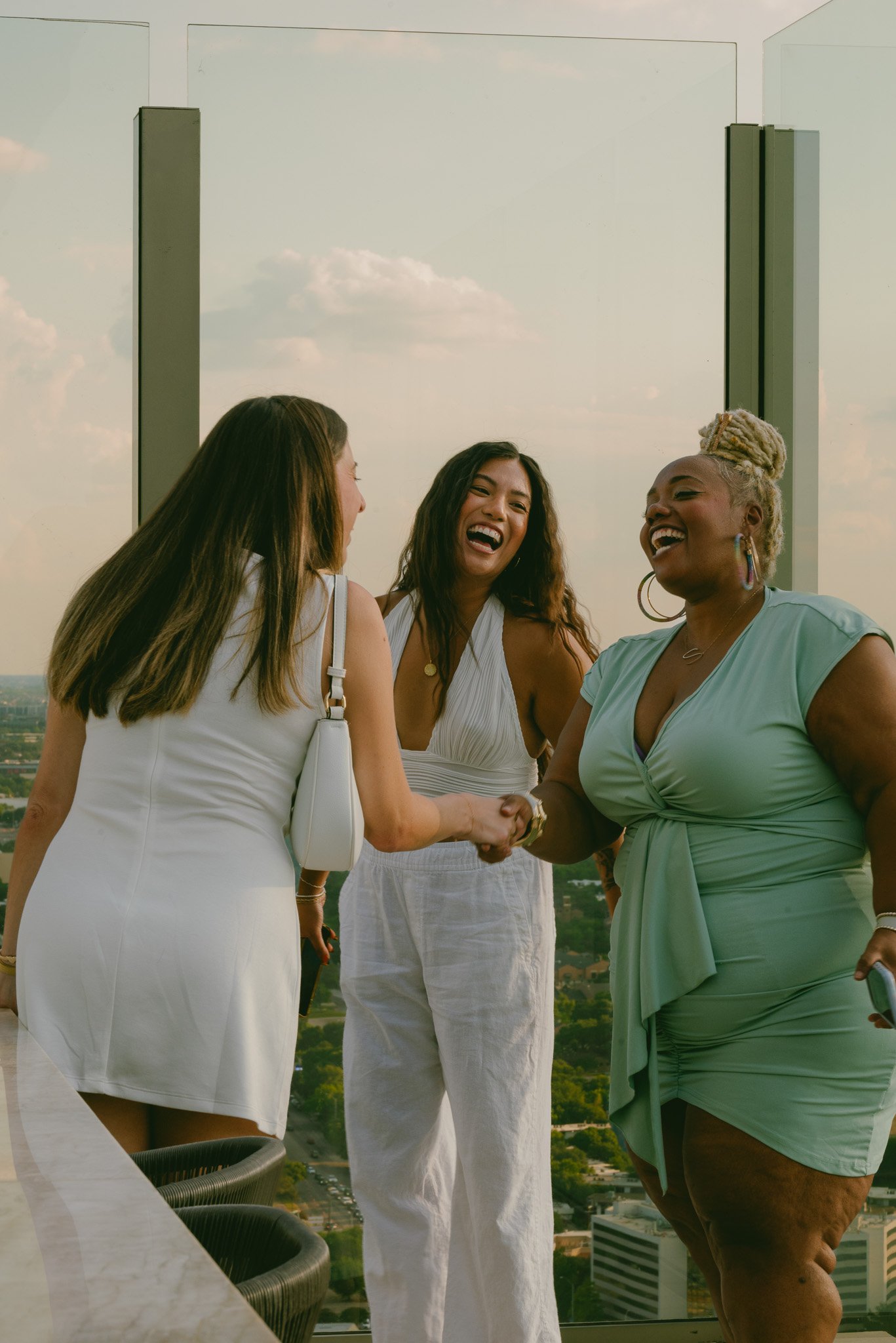 A group of women greeting one another while dressed in elevated summer attire