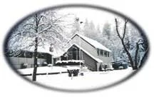 A snowy winter scene featuring a house with snow-covered trees and a fence in the foreground.
