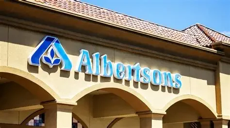 Exterior view of an Albertsons grocery store with a blue sign and a logo on the building facade.