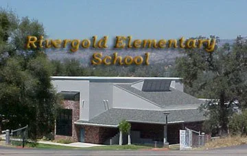 Rivergola Elementary School sign and building with trees and sky in the background.