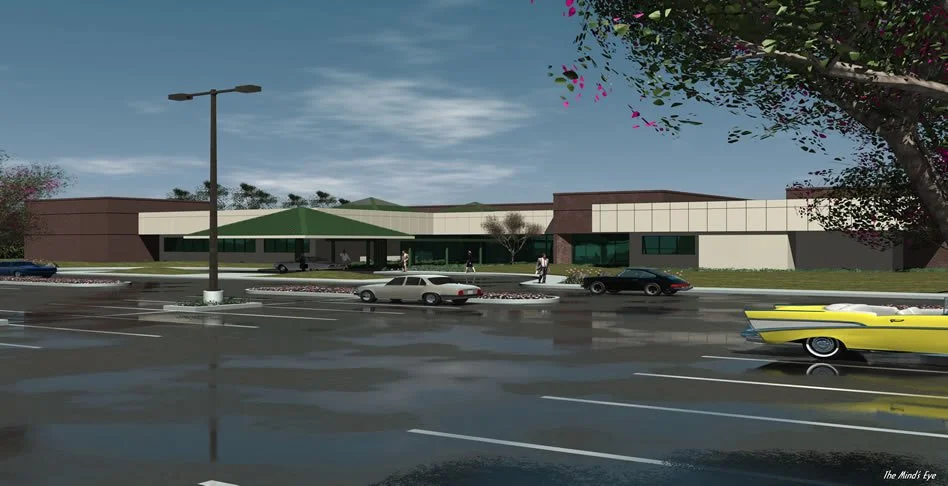 A modern shopping mall with a parking lot, several cars parked, and a classic yellow car driving by. Pedestrians are walking near the entrance under a green awning, with trees and a blue sky overhead.