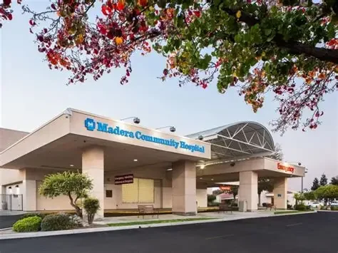 Exterior of Madera Community Hospital with trees and parking lot