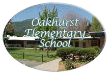 Sign for Oakhurst Elementary School with trees and a building in the background.
