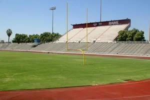 Empty football field with goalpost and bleacher seats in the background