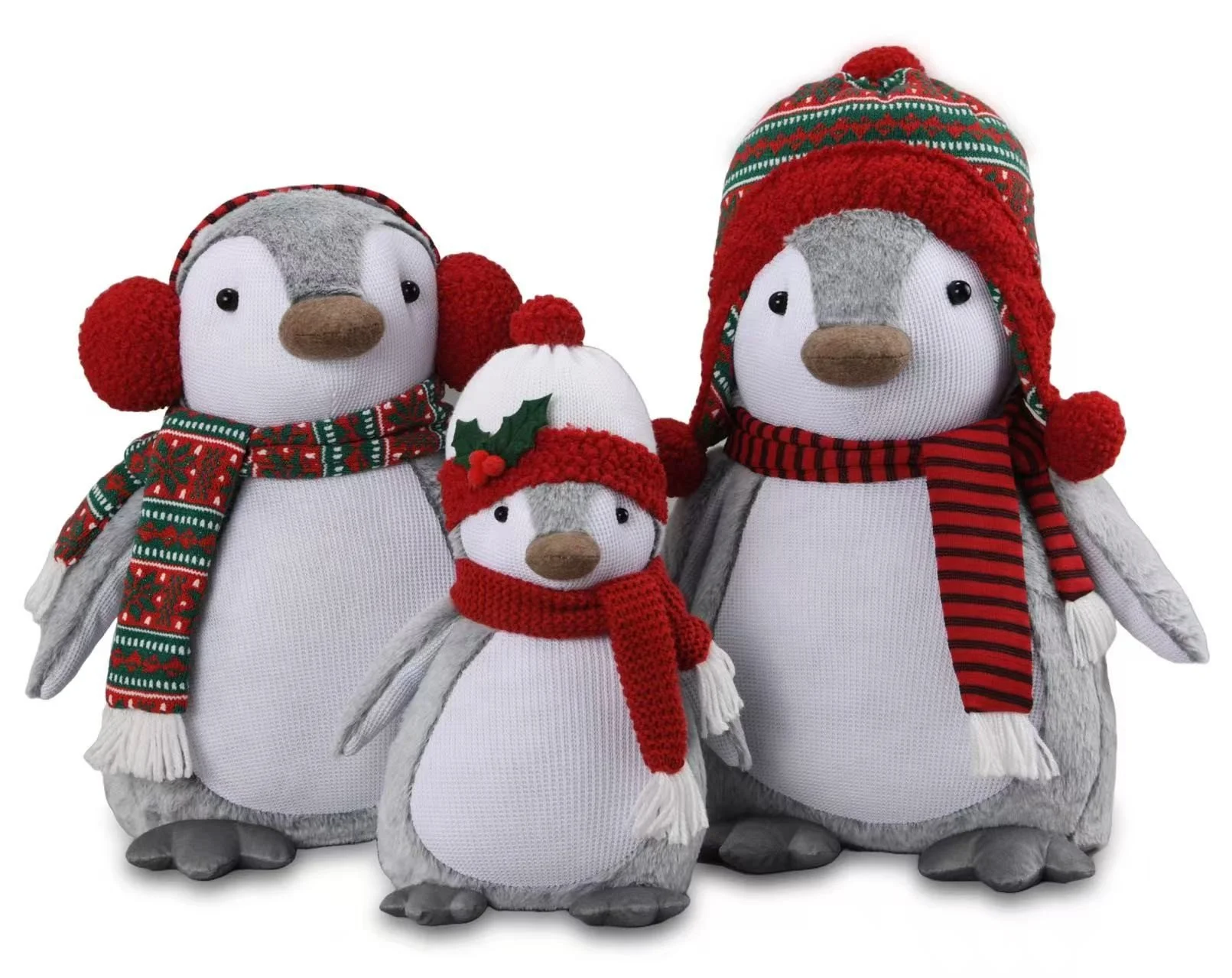 Three plush penguin toys dressed in Christmas accessories with red, white, and green colors, one with a Santa hat and holly, and others with scarves and hats.