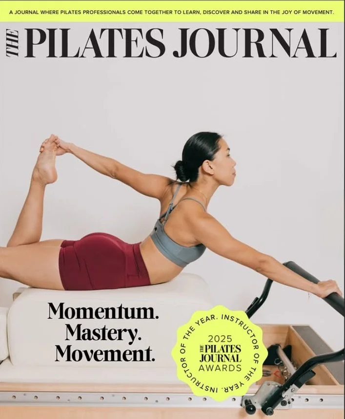Woman performing Pilates exercise on a reformer machine, reaching forward with one arm and holding her ankle with the other leg positioned behind her. The cover features the title 'The Pilates Journal' and headlines emphasizing 'Momentum, Mastery, Movement.' There is also a yellow badge indicating the 2025 Instructor of the Year Award from The Pilates Journal.