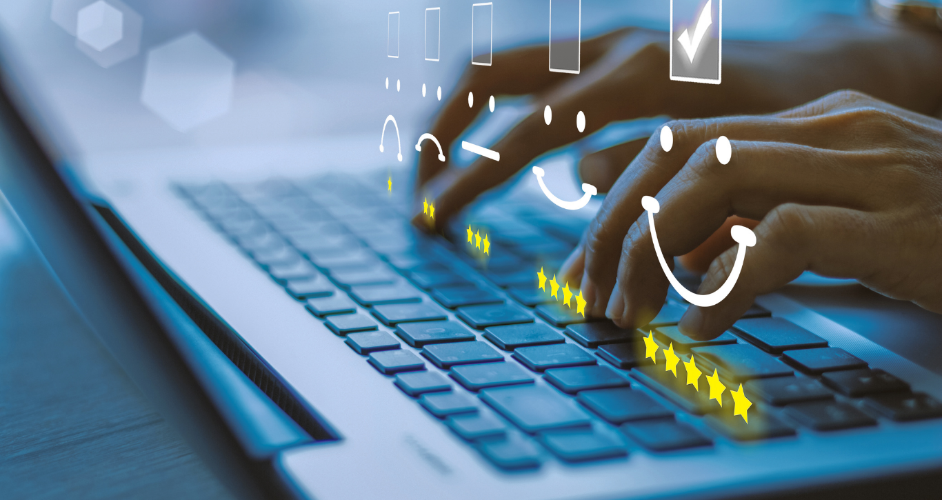 Hands typing on a laptop keyboard with digital icons and smiley faces overlaid, representing customer satisfaction and online activity.