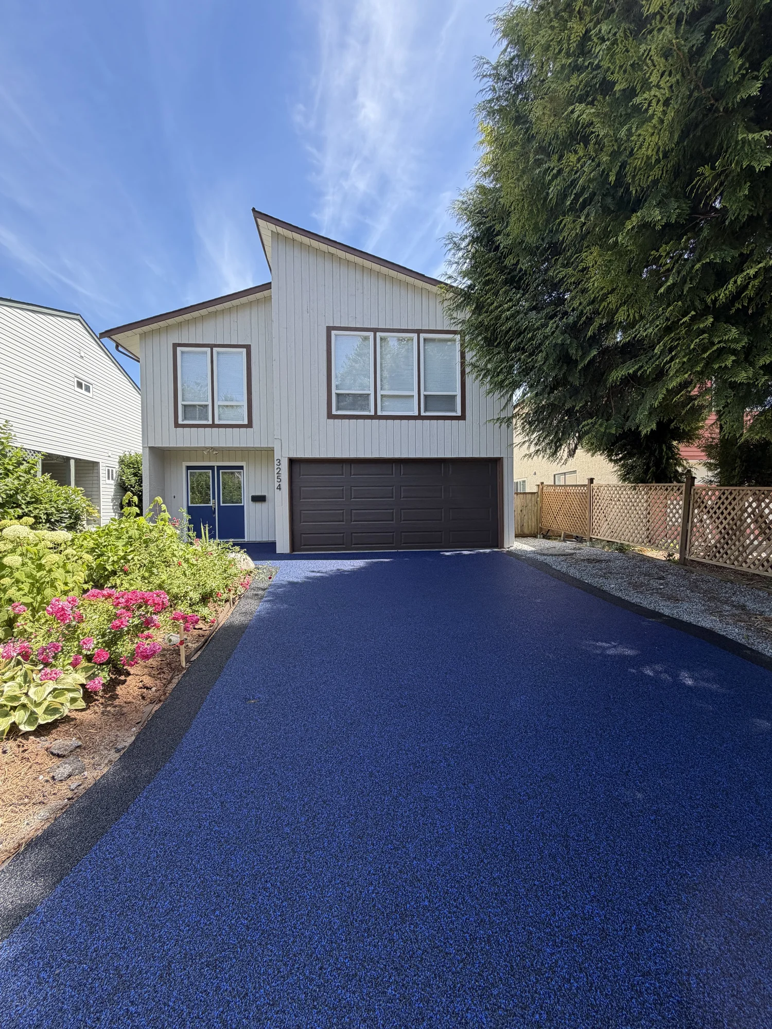 Finished dark rubber driveway leading to a residential garage