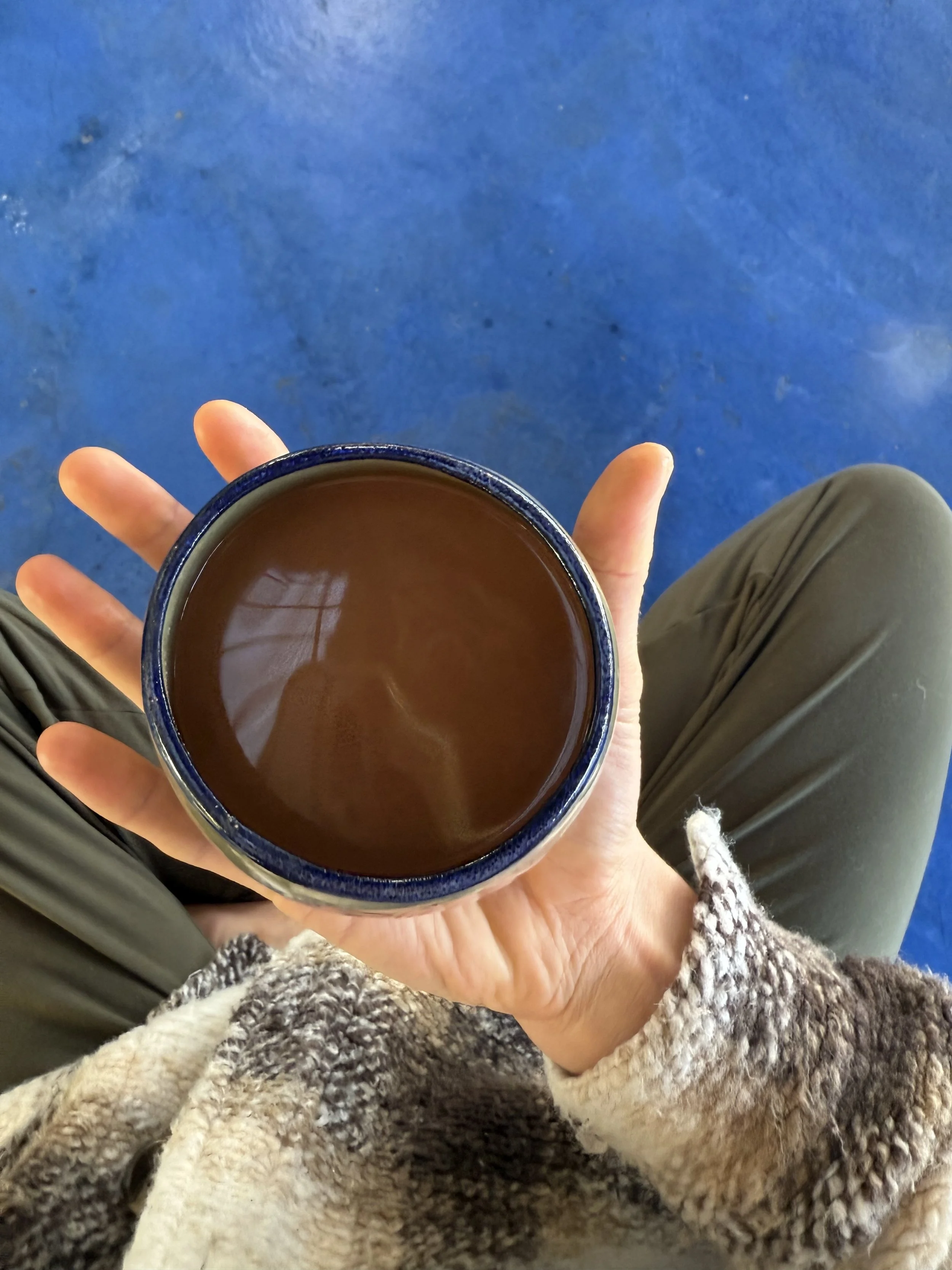 Hands holding a cup of quality ceremonial cacao