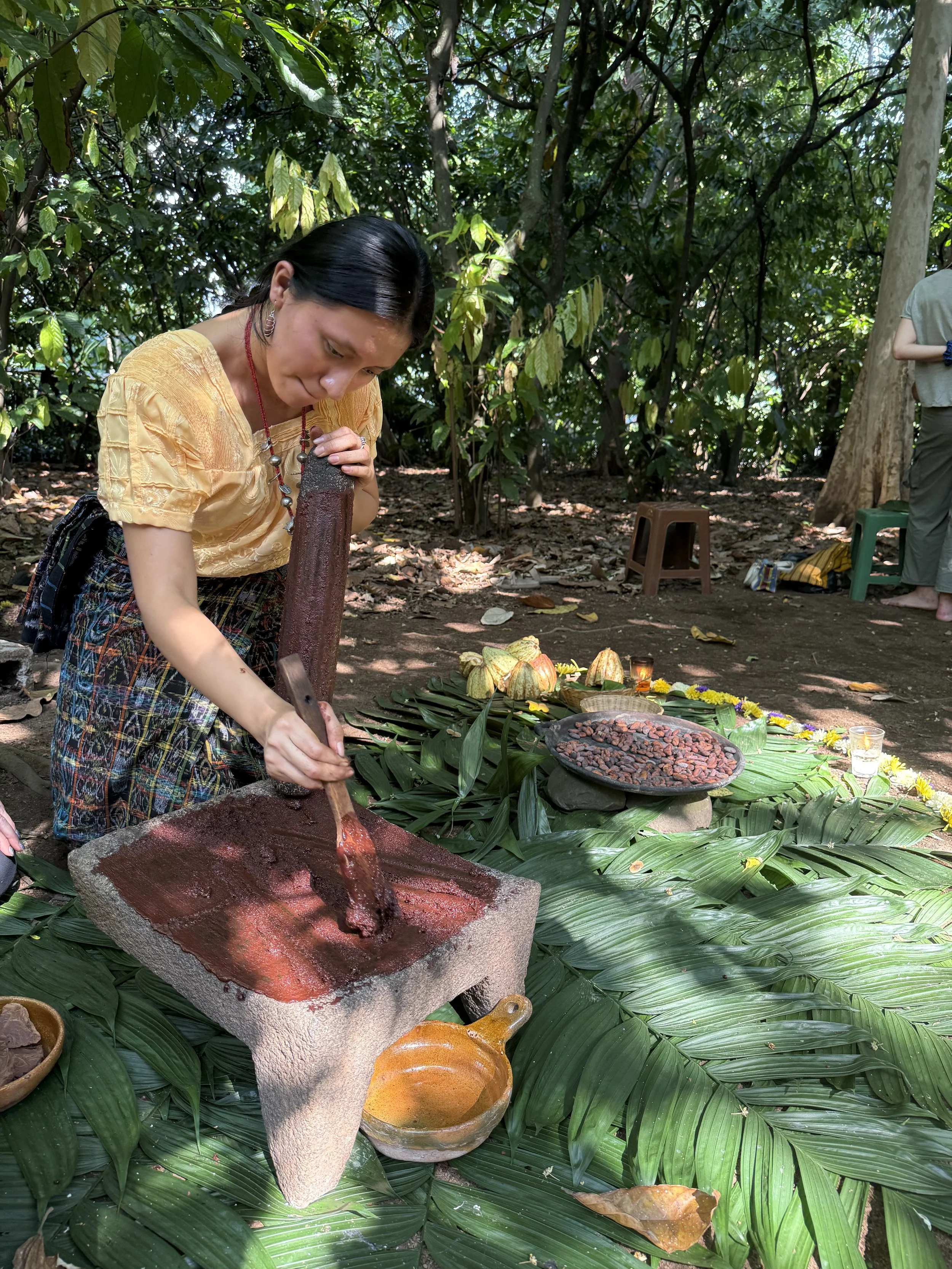 Traditional cacao preparation using stone tools outdoors