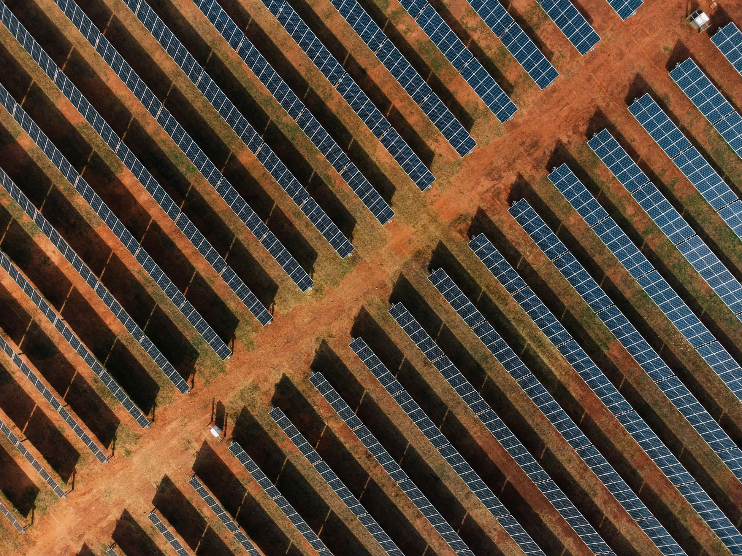 an array of solar panels on red earth ground