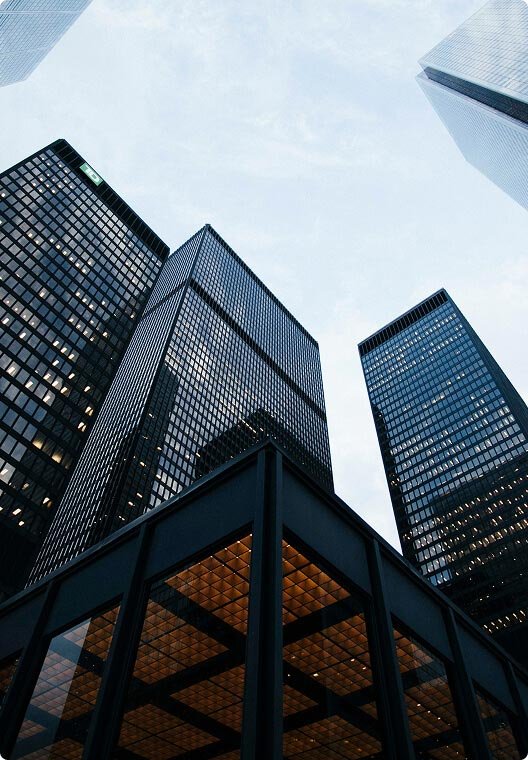 Looking up at tall modern skyscrapers with glass facades in a city
