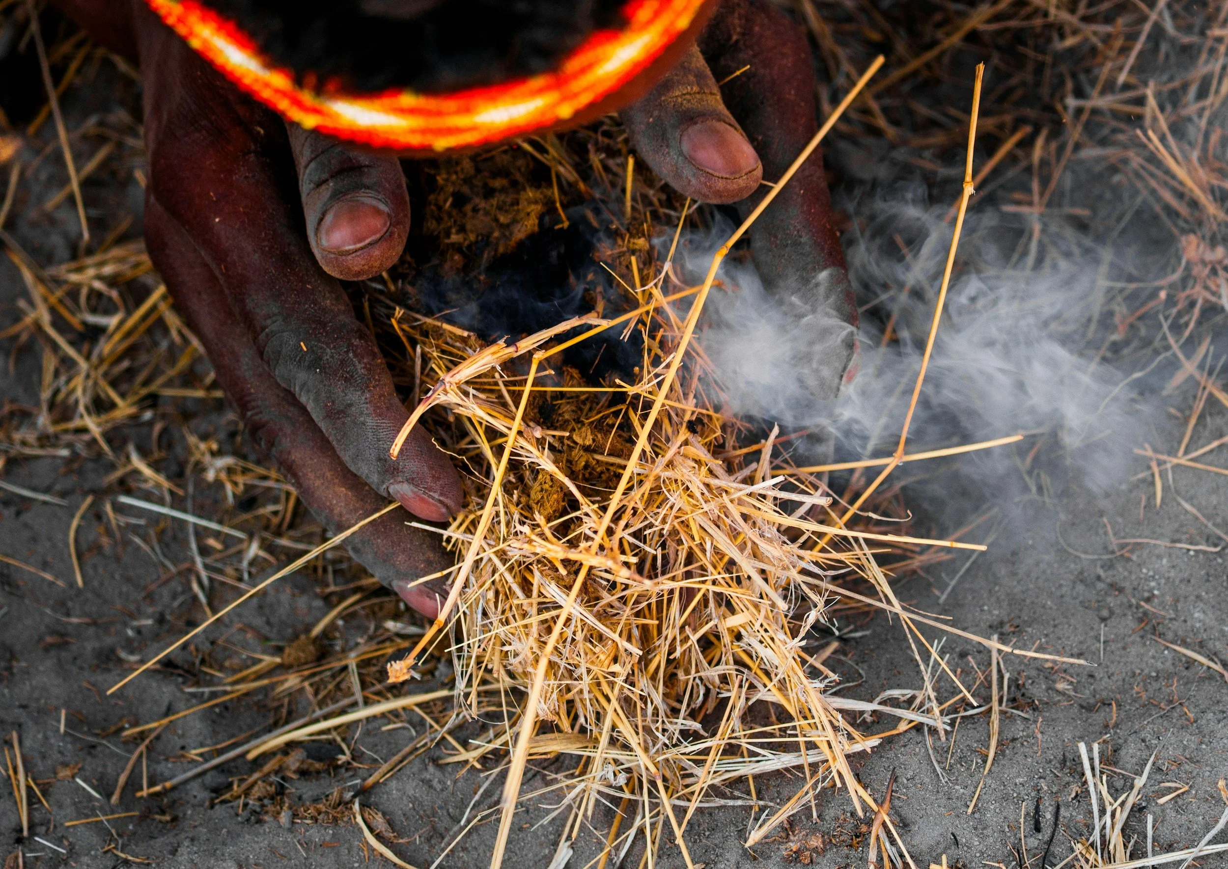 Traditional fire making using dry grass in the Botswana bush.
