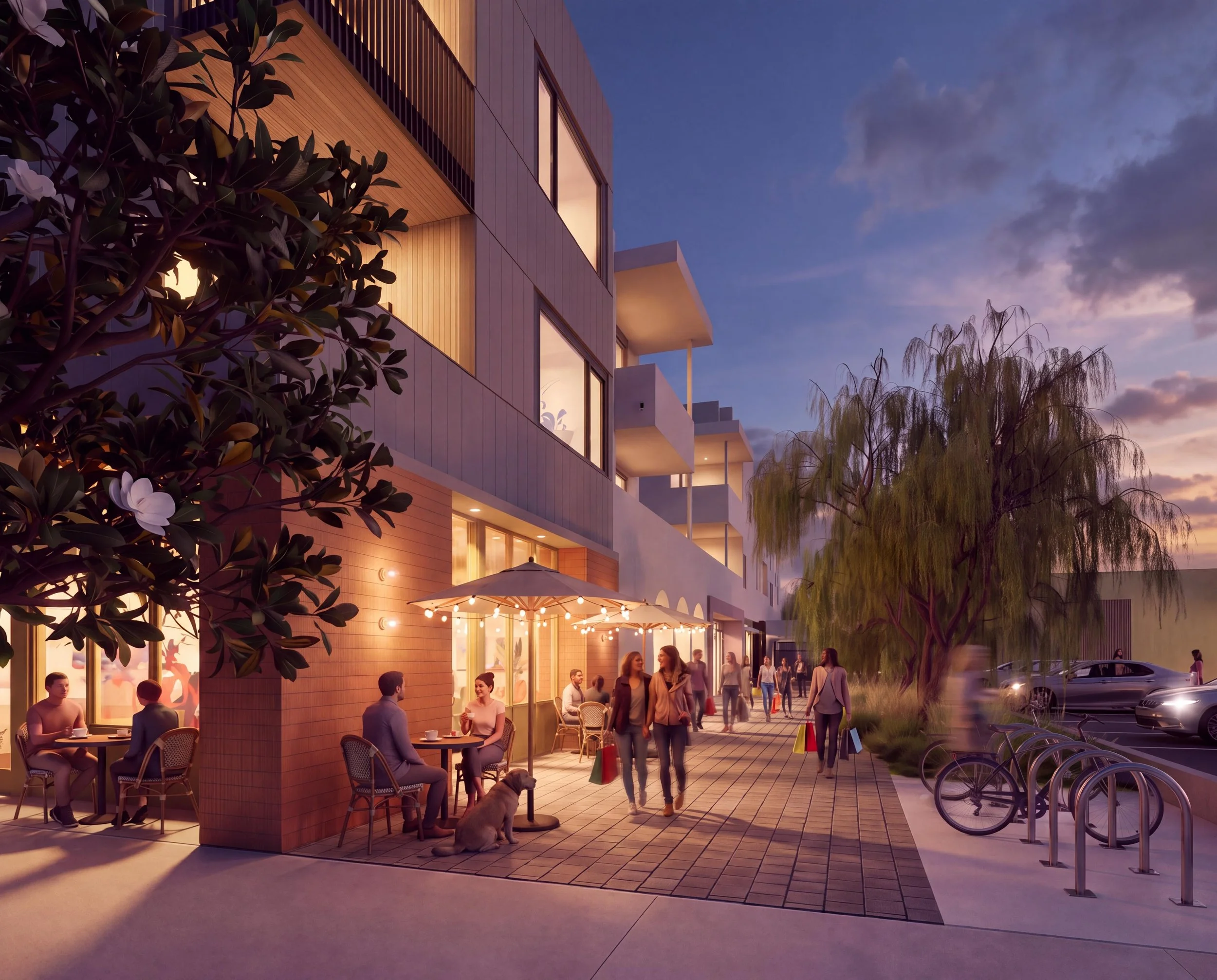 People dining and socializing outside a modern building with warm lighting, during twilight, with bicycles parked nearby and trees in the surroundings.