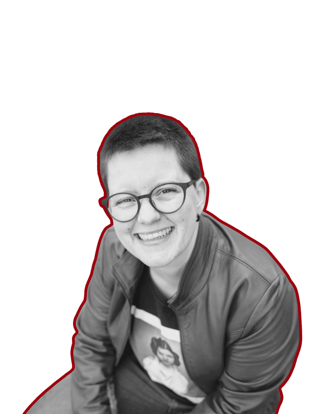 Mensch mit kurzen Haaren, Brille und Lächeln, trägt Lederjacke und T-Shirt mit Frauengesicht, sitzend, schwarz-weiß