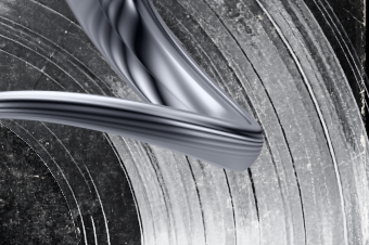 Close-up of a shiny, metallic object curling in a spiral, set against a textured, abstract background.