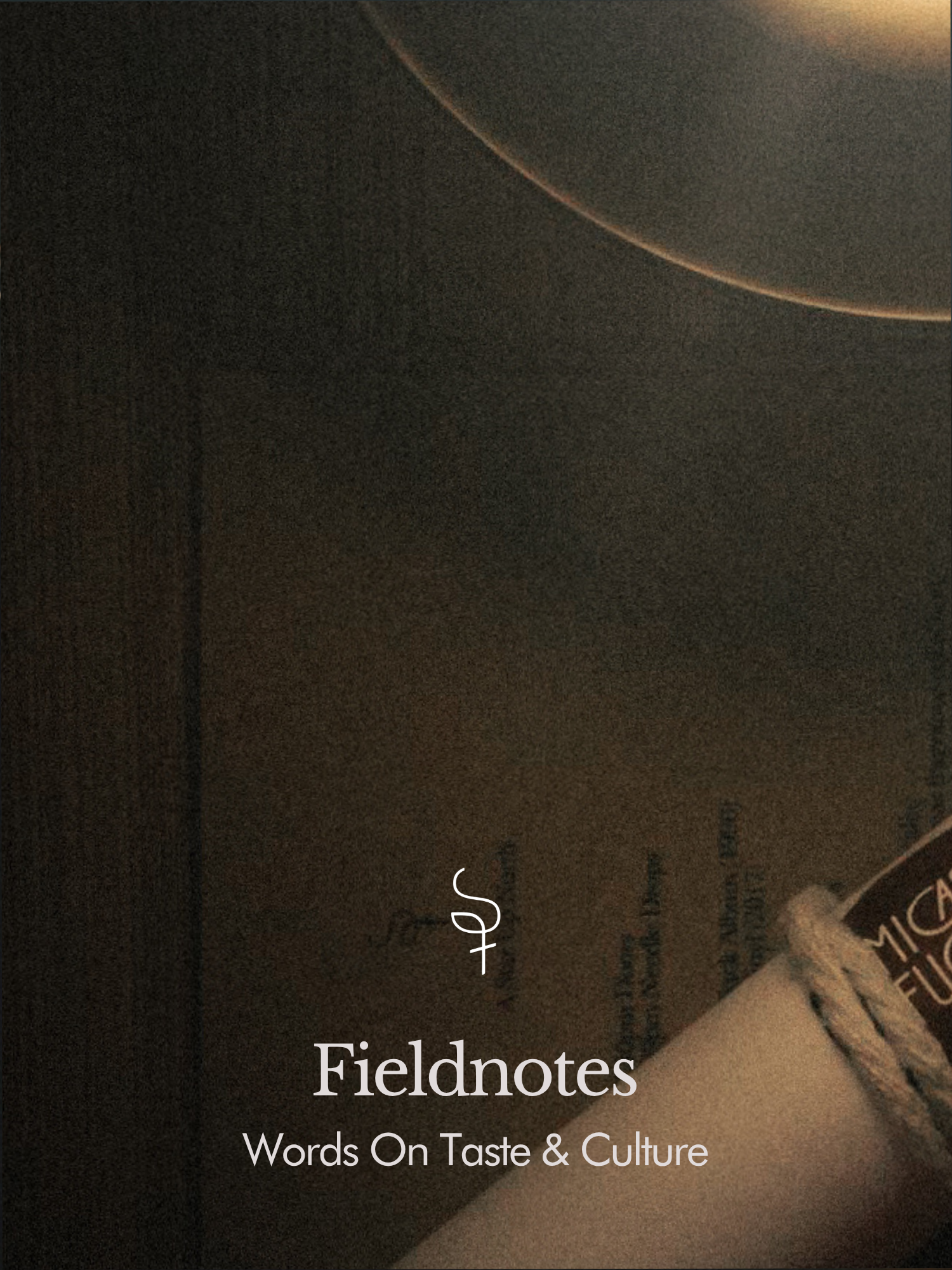 Close-up of a book titled "Fieldnotes: Words On Taste & Culture" with part of a pen visible at the bottom right corner.
