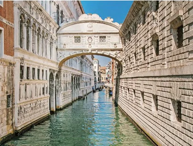 Kanal in Venedig mit Brücke und historischen Gebäuden.