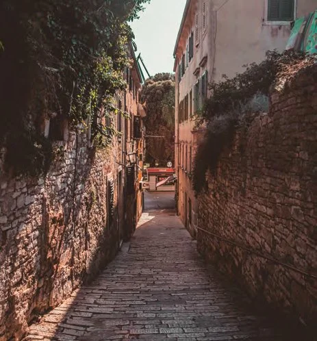 Enge, steinige Gasse zwischen alten Gebäuden in einer Stadt.