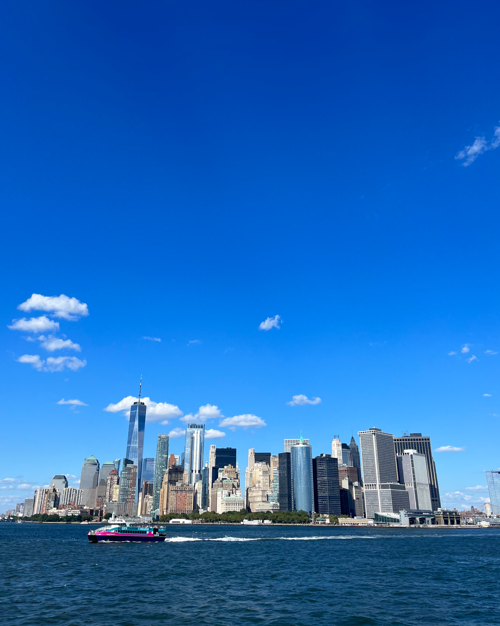 Skyline of Manhattan, New York City, from across the water with a boat in the foreground