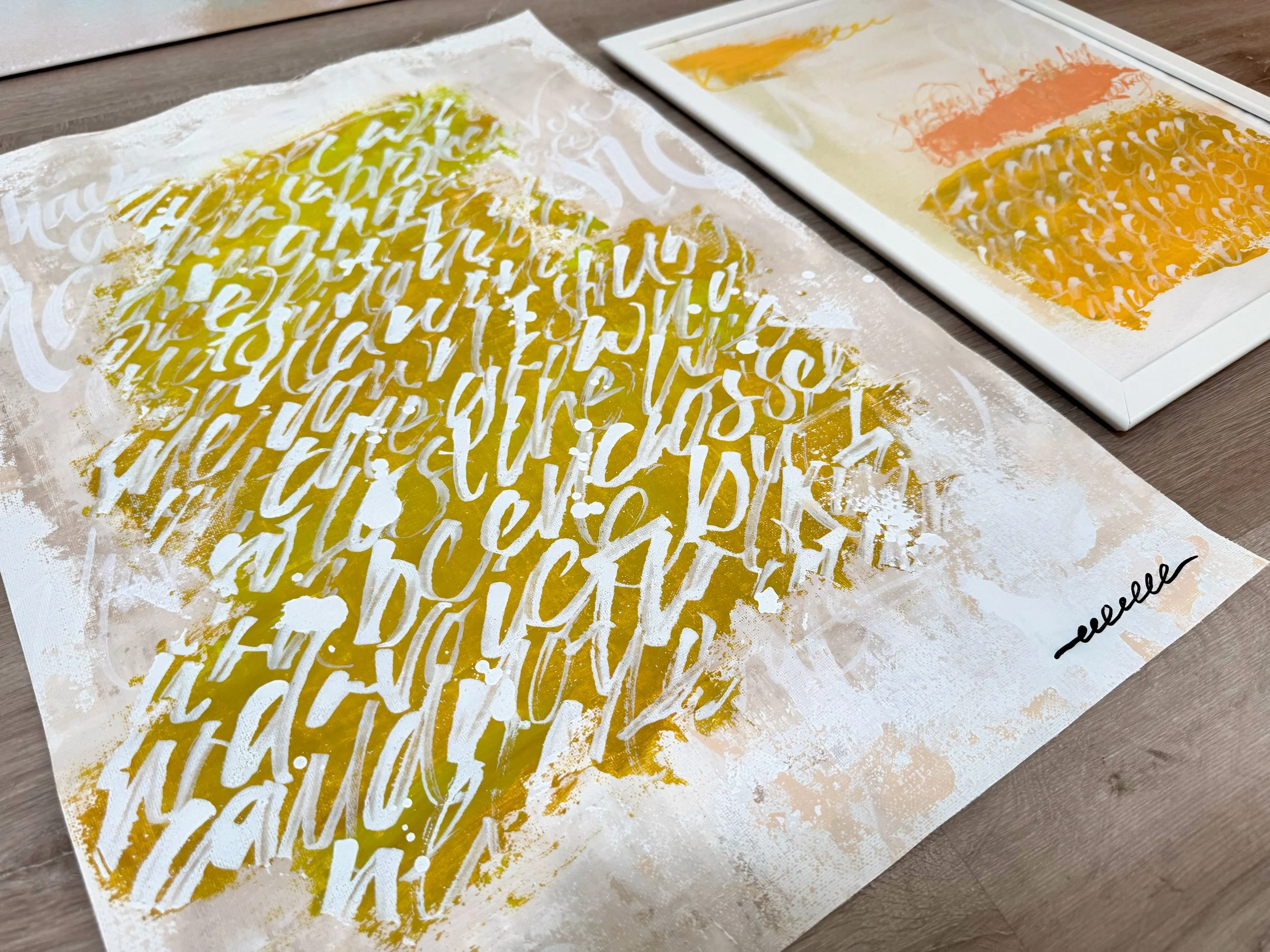 Arte en papel con letras blancas sobre fondo amarillo y texto en color blanco y negro en la esquina inferior derecha.