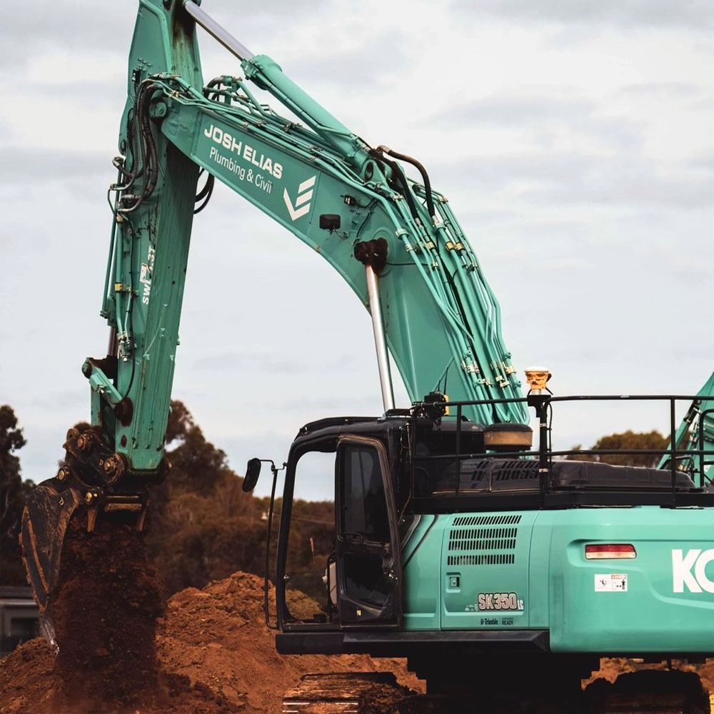 JEPC excavator digging into the dirt with a bucket attachment at a construction site 
