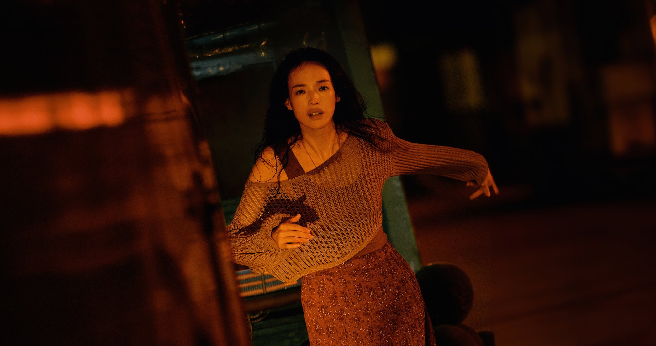 Unit still of an actress running through a nighttime scene, photographed on set.
