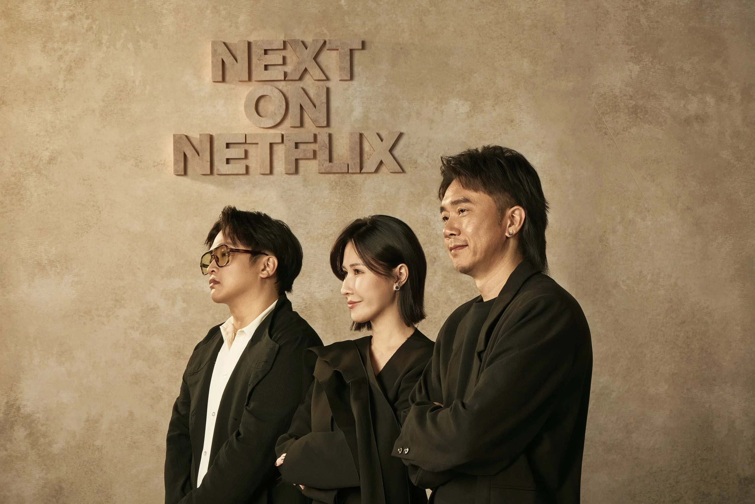 Campaign portrait from Next on Netflix featuring three creative leads posed against a textured backdrop, emphasizing collaboration and leadership behind the slate.