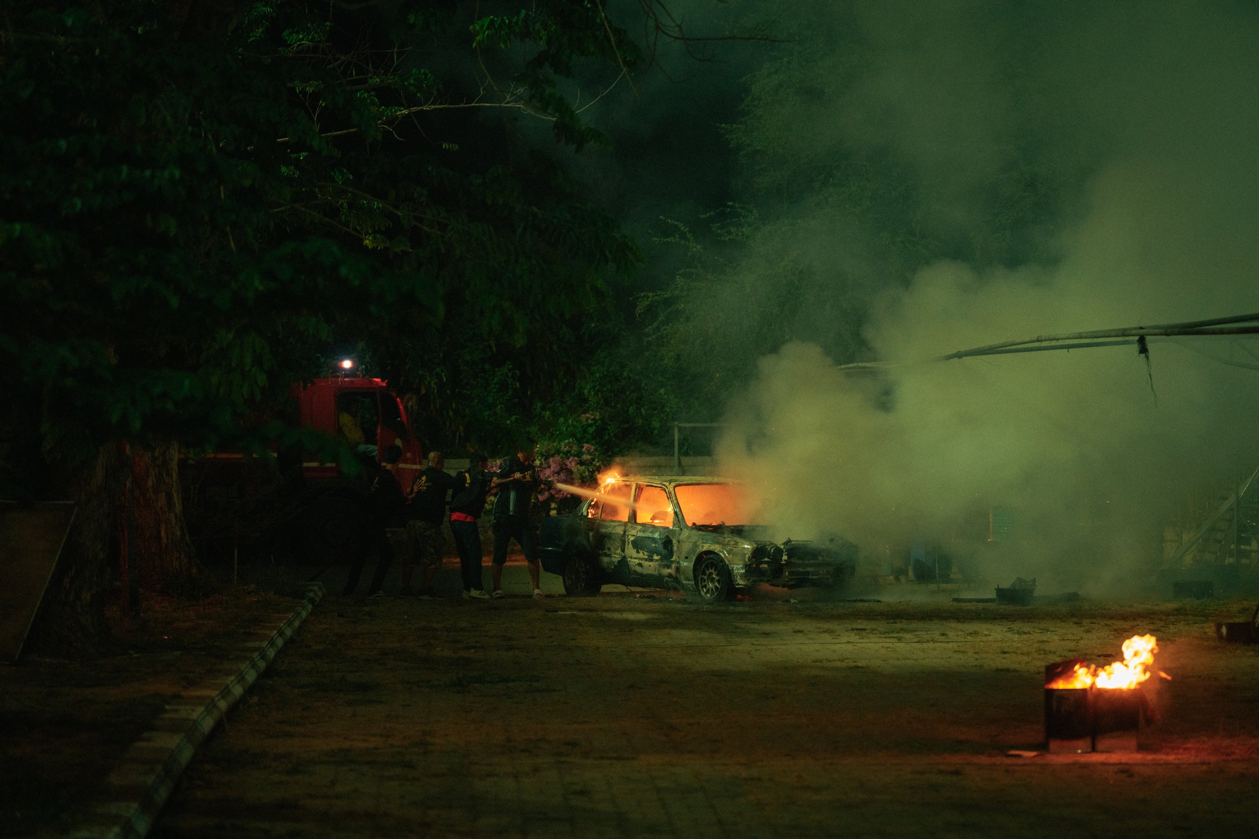 Night shoot action sequence with smoke and fire effects captured on set during production.