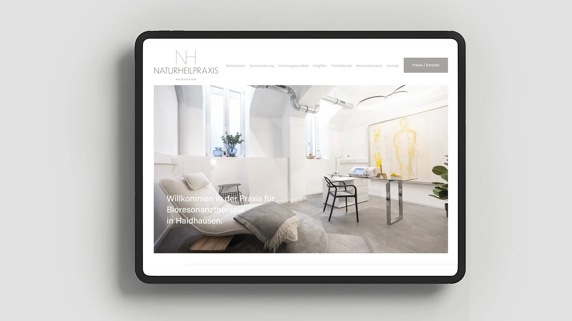 Startseite einer Webseite für eine Naturheilpraxis mit einem modernen, hellen Behandlungsraum, einem Liegestuhl, Pflanzen, Fenstern, Kunst und medizinischer Ausrüstung.