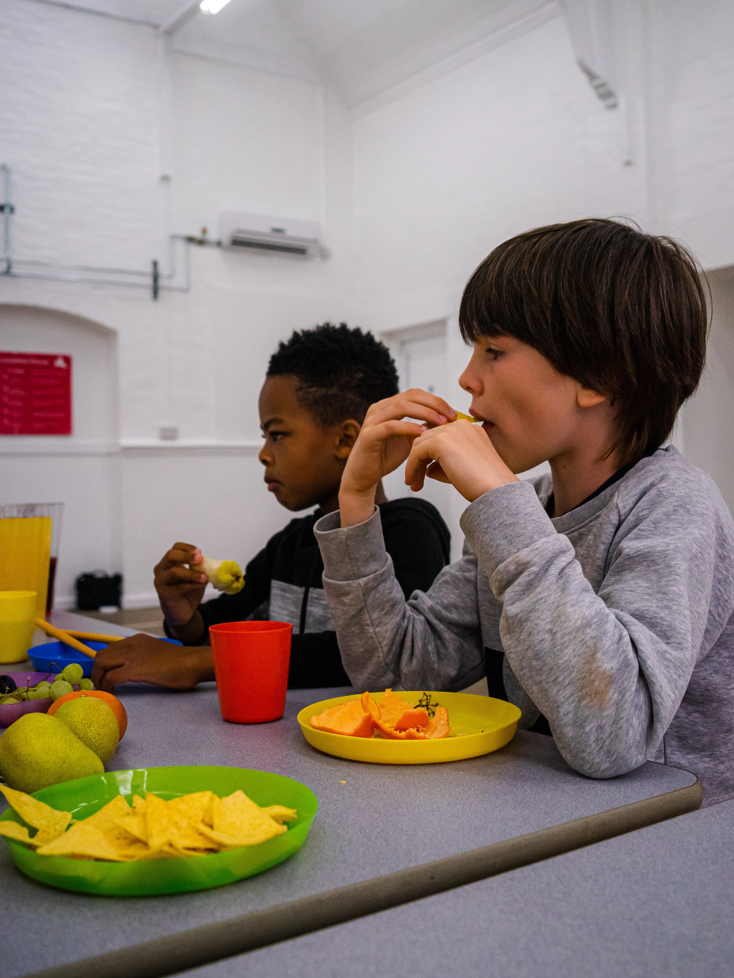 Children enjoying a snack together at Global Camps